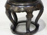 a black stool with a gold design on it
