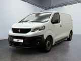 La petite camionnette blanche est garée dans une grande pièce.