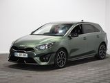 La voiture verte est garée dans une pièce au sol à carreaux.