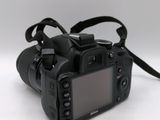 a black camera with a strap on it on a white surface