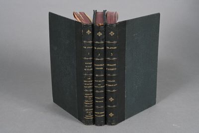two books are stacked on top of each other on a gray surface