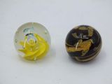 two glass marbles sitting next to each other on a table