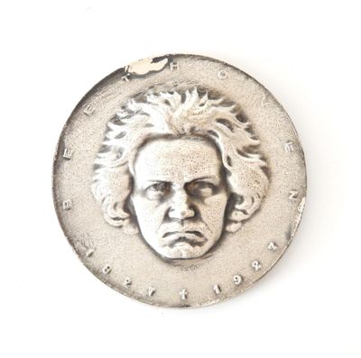 a silver coin with a face of a man on it