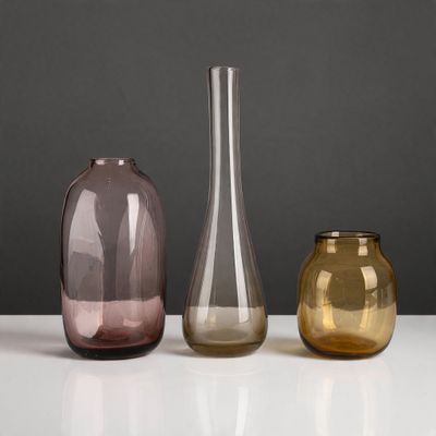 trois vases de couleurs différentes posés sur une table blanche