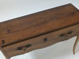 a small wooden table with a drawer on it