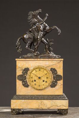 an antique clock with a bronze statue of a man on a horse on a marble base