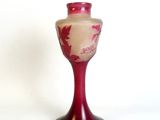 un vase rouge posé sur un socle noir