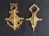two pieces of gold metal on a black surface