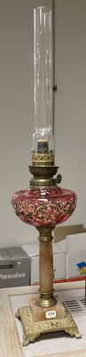 a red and gold glass lamp on a wooden table