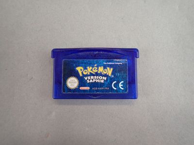 the gameboy is sitting on the table next to the blue case