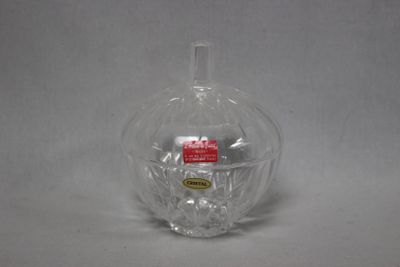 un vase en verre transparent orné d'une étiquette rouge