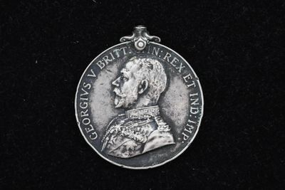 un gros plan d'une médaille posée sur une surface noire, avec un fond noir