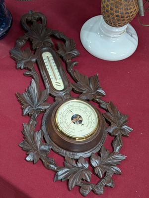 une horloge et un thermomètre posés sur une table