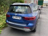 a blue car that is parked on the side of the road