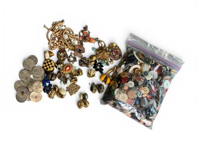 un sachet contenant un assortiment de boutons et de bijoux posé sur une surface blanche
