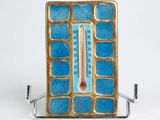 un thermomètre posé sur un support, sur une surface blanche