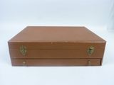 a brown suitcase sitting on top of a white table