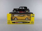 a black toy car sitting on top of a yellow box