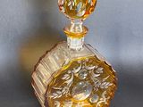 yellow glass perfume bottle with a floral design on the top