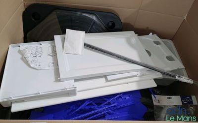 une boîte remplie d'appareils électroniques, avec un ordinateur portable à l'intérieur