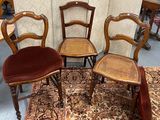 three wooden chairs sitting on top of a rug in a room