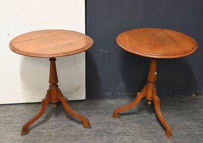une paire de tables d'appoint anciennes en bois, posées sur des socles, devant un mur noir