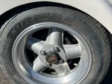un camion blanc avec un pneu crevé, garé sur un parking