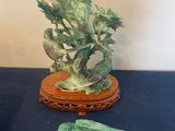 une statue représentant un oiseau posée sur une table, à côté d'un vase
