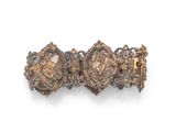 a close up of a gold bracelet with ornate designs on it