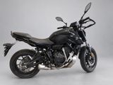 the black motorcycle is parked in a studio with a gray background