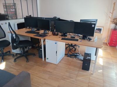 trois écrans d'ordinateur posés sur le bureau de ce bureau