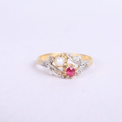 un gros plan d'une bague en or sertie d'une perle et d'un rubis