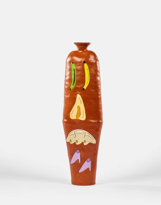 un vase marron orné d'un motif sur fond blanc