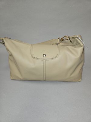 beige leather handbag with zippers and zipper closures