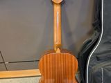 a close up of a guitar and a guitar case on the floor