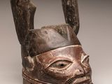 gros plan d'un masque en bois sur une surface blanche