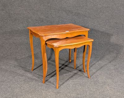 deux tables gigognes en bois posées sur une surface grise, avec un fond gris