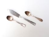 three spoons and a knife on a white table
