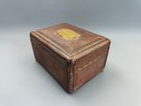 une vieille boîte en cuir marron ornée d'un emblème doré