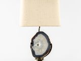 a table lamp with a white shade on top of it