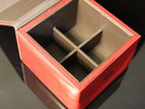 a small red box with four compartments on a table