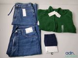 two pairs of jeans and a green shirt on a table