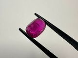 a close up of a pink diamond being held by a pair of pliers