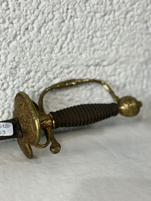 a small sword that is laying on a white surface