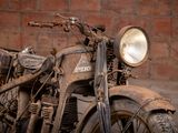a old motorcycle that is parked in front of a brick wall