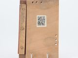 un livre en bois orné d'un dessin, posé sur une surface blanche