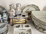 many pieces of pottery sitting on a white table