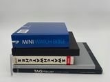 trois livres empilés sur une surface blanche