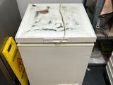 a small white chest freezer in the corner of a kitchen