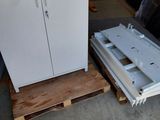 une armoire blanche posée sur une palette, à côté d'une palette en bois
